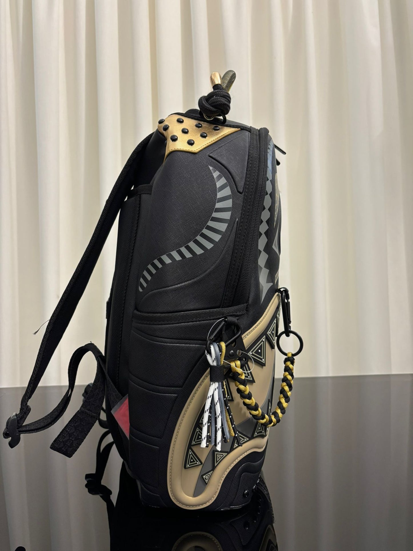 AI WONDERLAND GOLD AND BLACK BACKPACK SPRAYGROUND