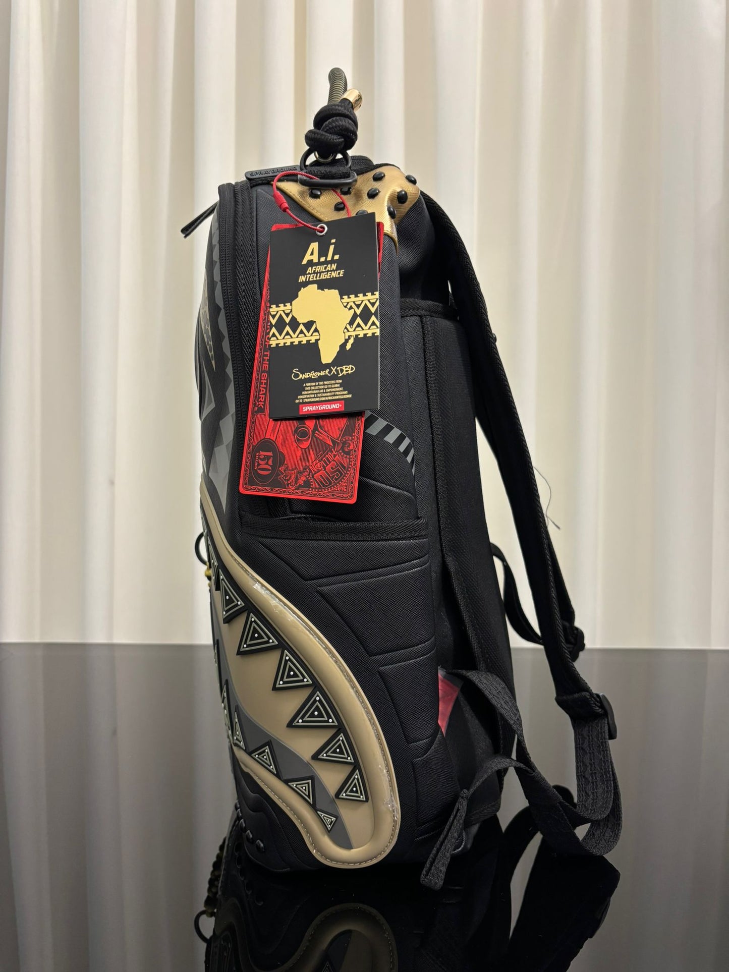 AI WONDERLAND GOLD AND BLACK BACKPACK SPRAYGROUND